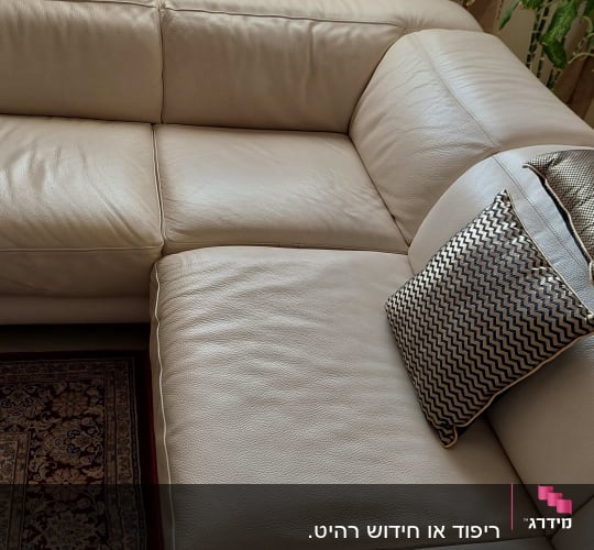 ספה מרופדת עם כרית דקורטיבית על מושב